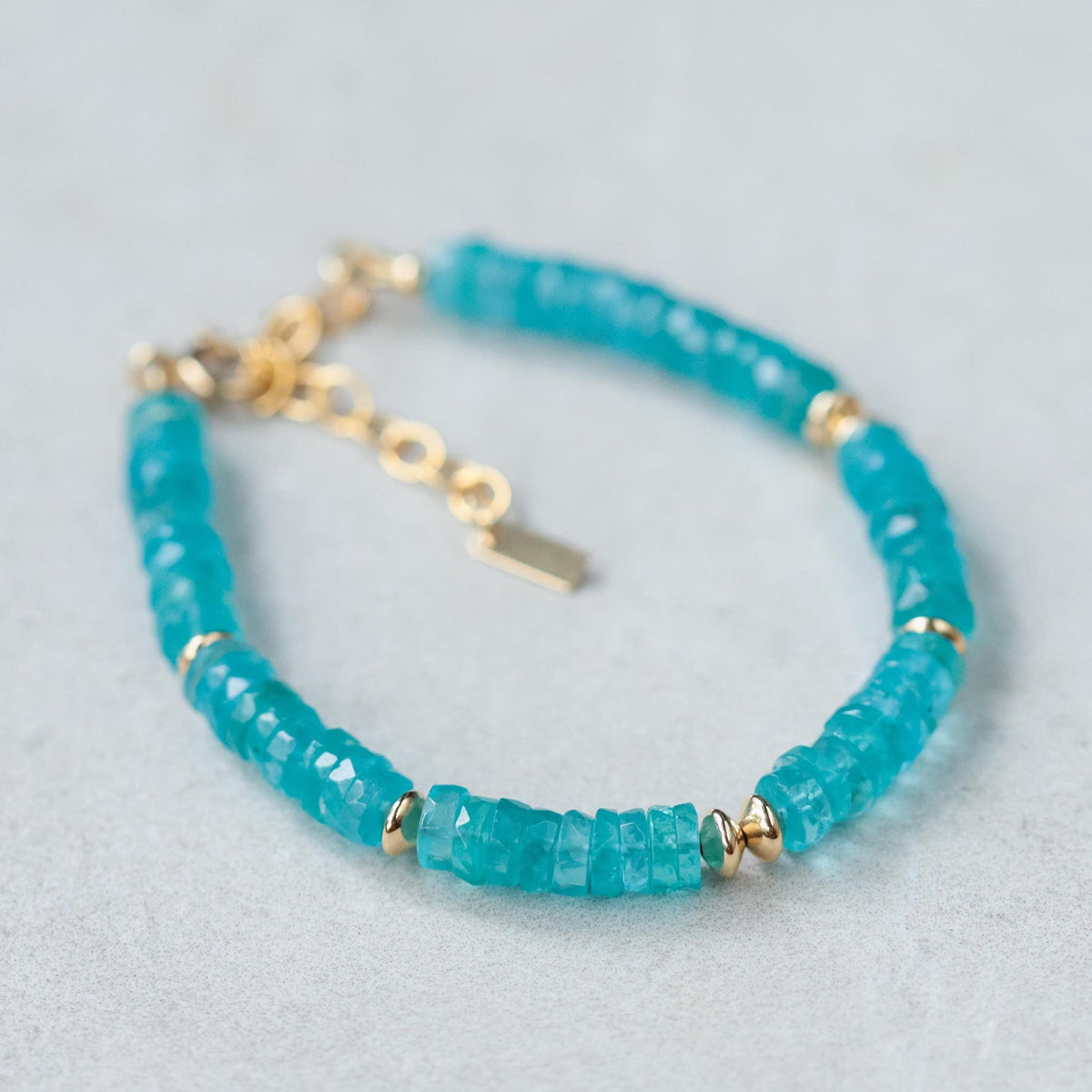 Neon Apatite bracelet with vibrant blue-green beads from Earthly Abundance, displayed on a neutral background.