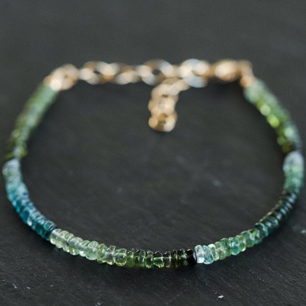 Green and blue tourmaline gemstone from Earthly Abundance Jewelry, showcasing vibrant, faceted stone with natural inclusions.