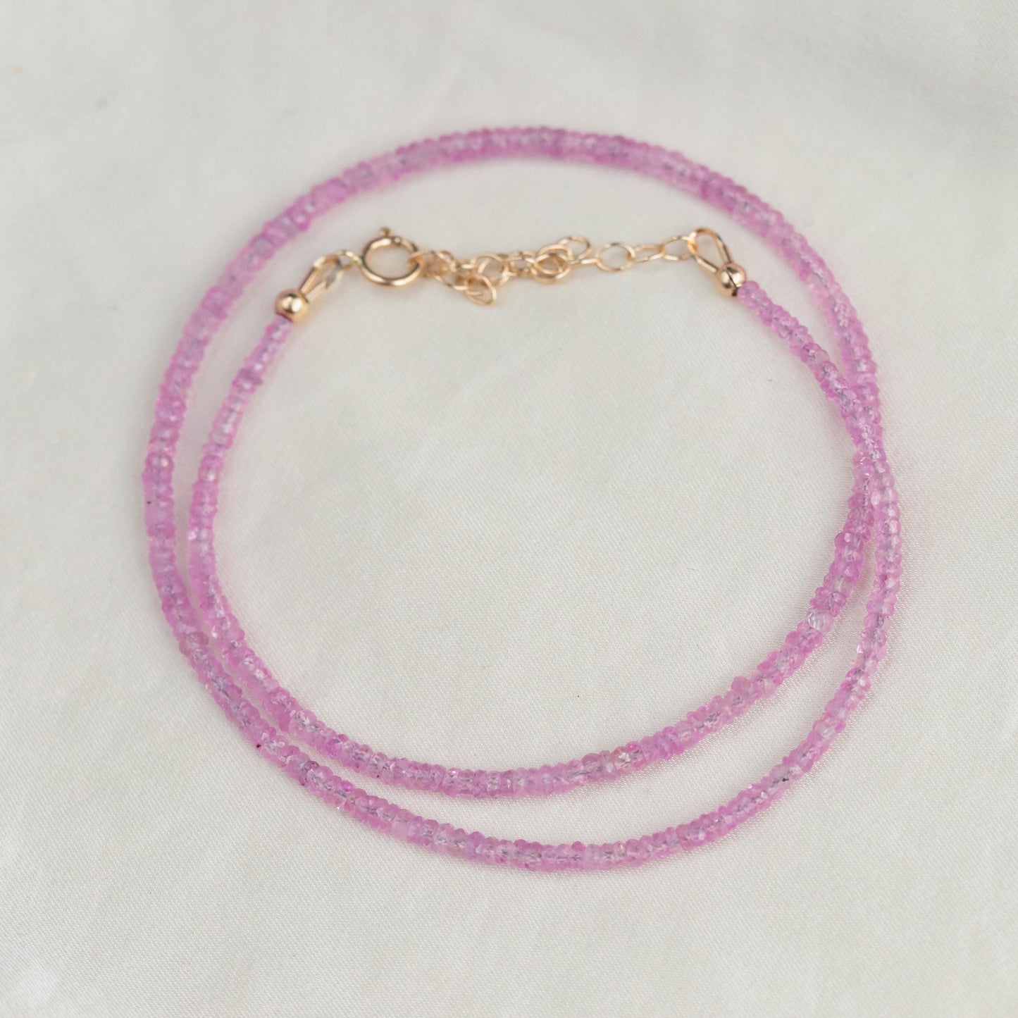 Pink sapphire necklace from Earthly Abundance featuring a string of vibrant pink sapphires on a delicate chain.