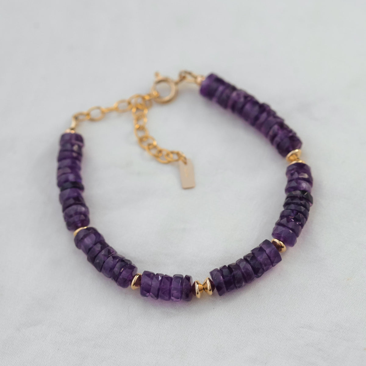 Earthly Abundance Amethyst Heishi bracelet featuring small purple gemstone beads on a stretch cord.