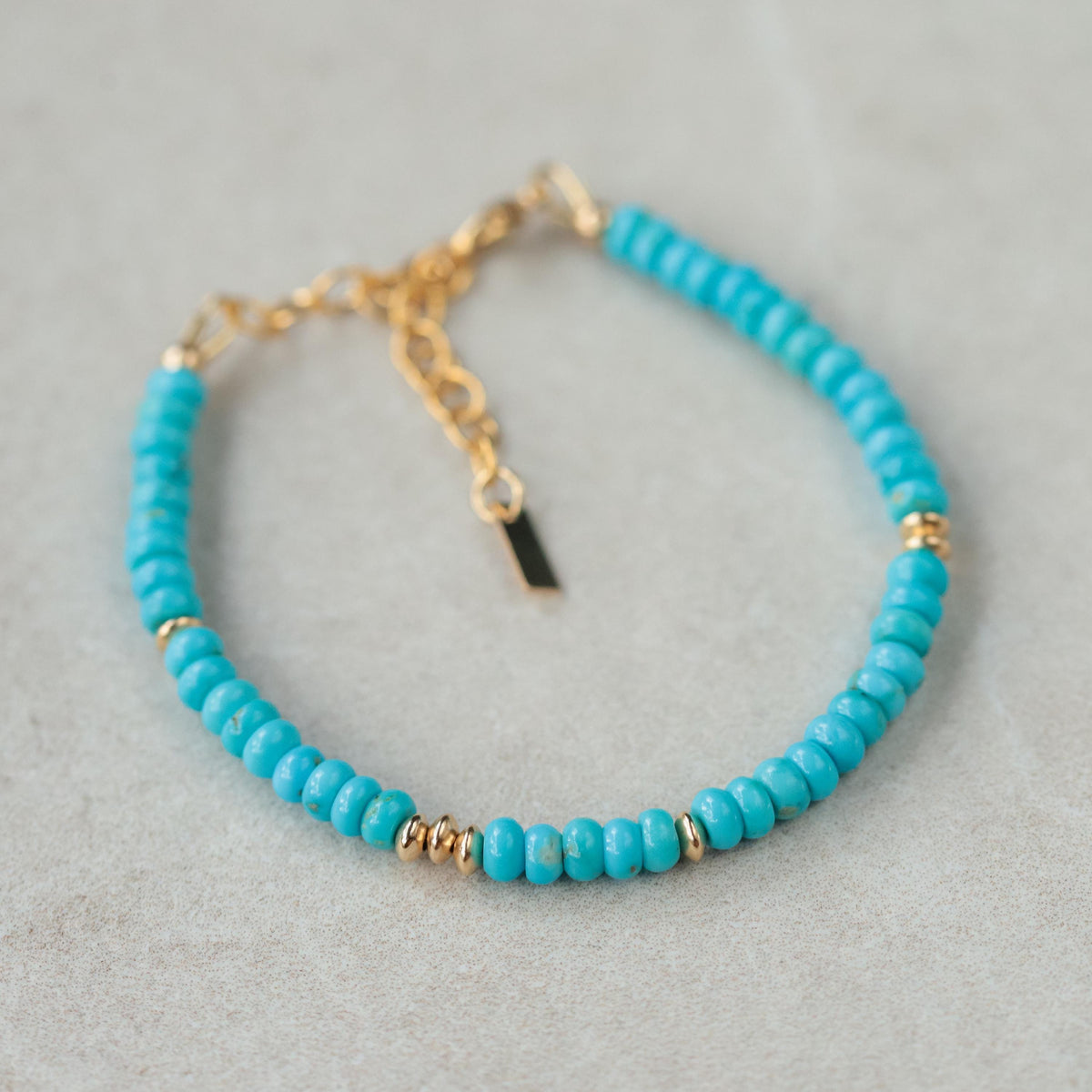 Smooth Rondel Sleeping Beauty turquoise gemstone from Earthly Abundance, showcasing its vibrant blue color and polished round shape.