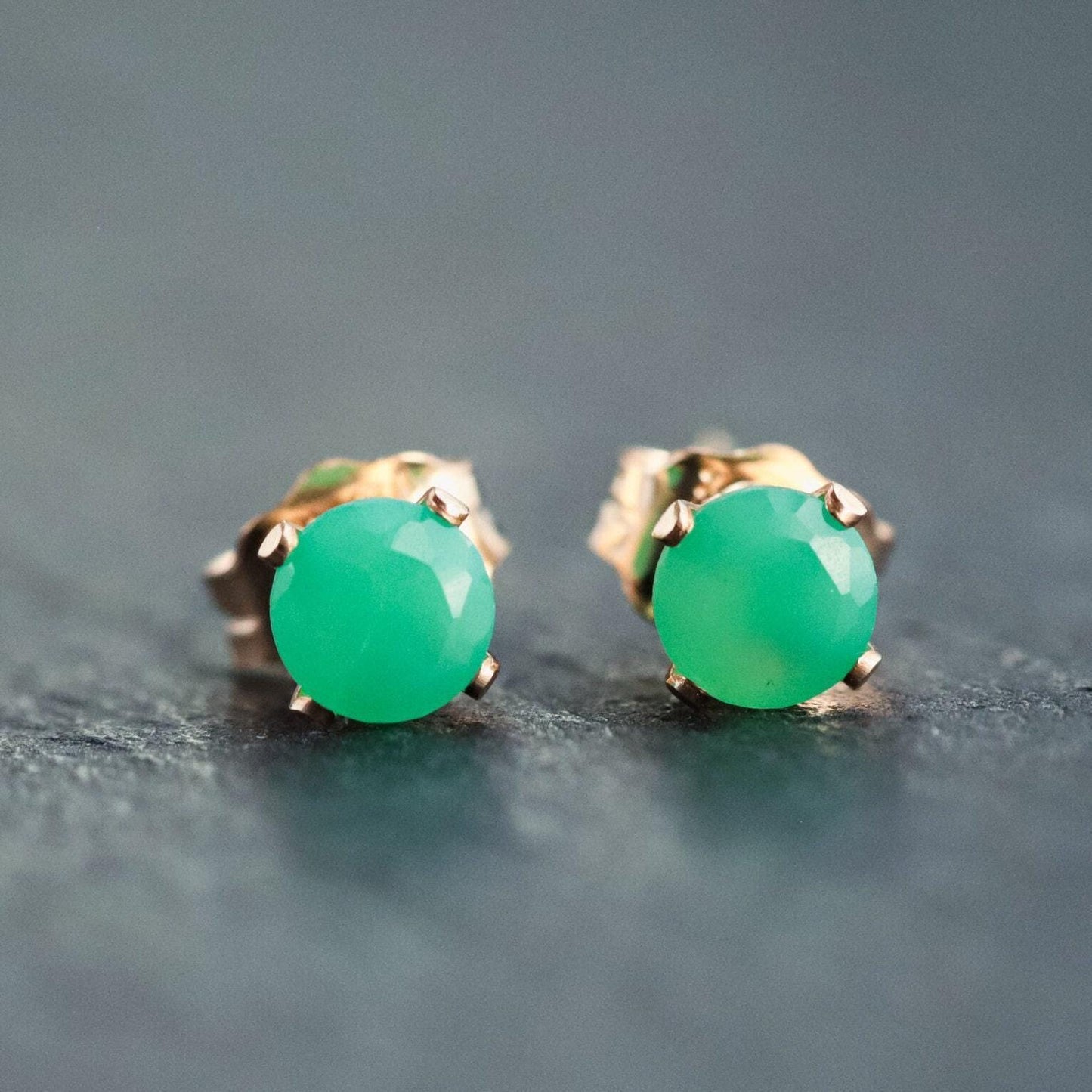 Pair of green chrysoprase stud earrings with silver settings from Earthly Abundance, close-up of the polished gemstone studs.