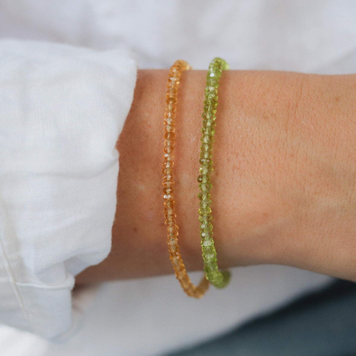 Peridot stacking bracelet by Earthly Abundance featuring multiple green gemstone beads on a delicate silver chain.