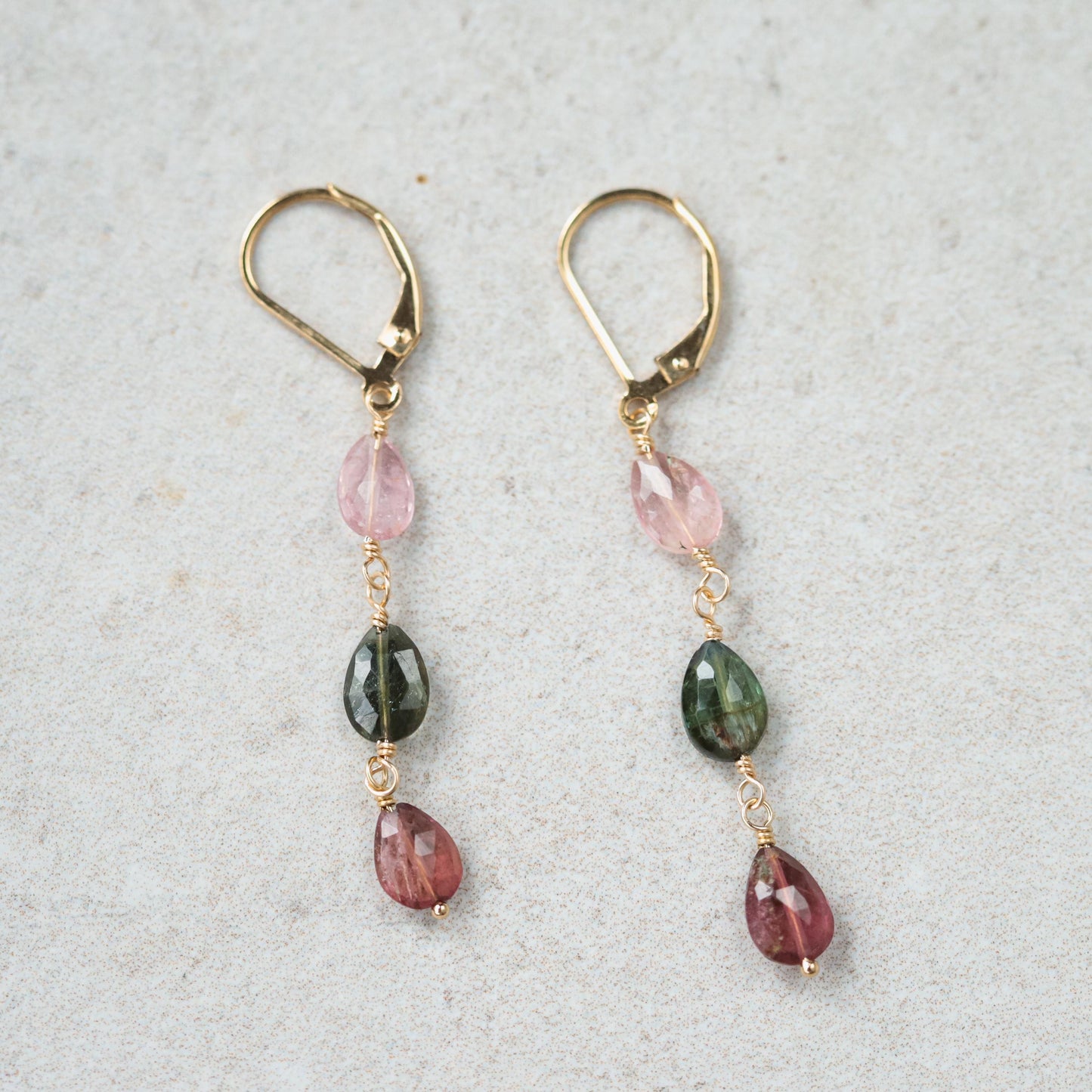 Delicate mixed tourmaline drop earrings by Earthly Abundance featuring colorful gemstone teardrops hanging from silver hooks.