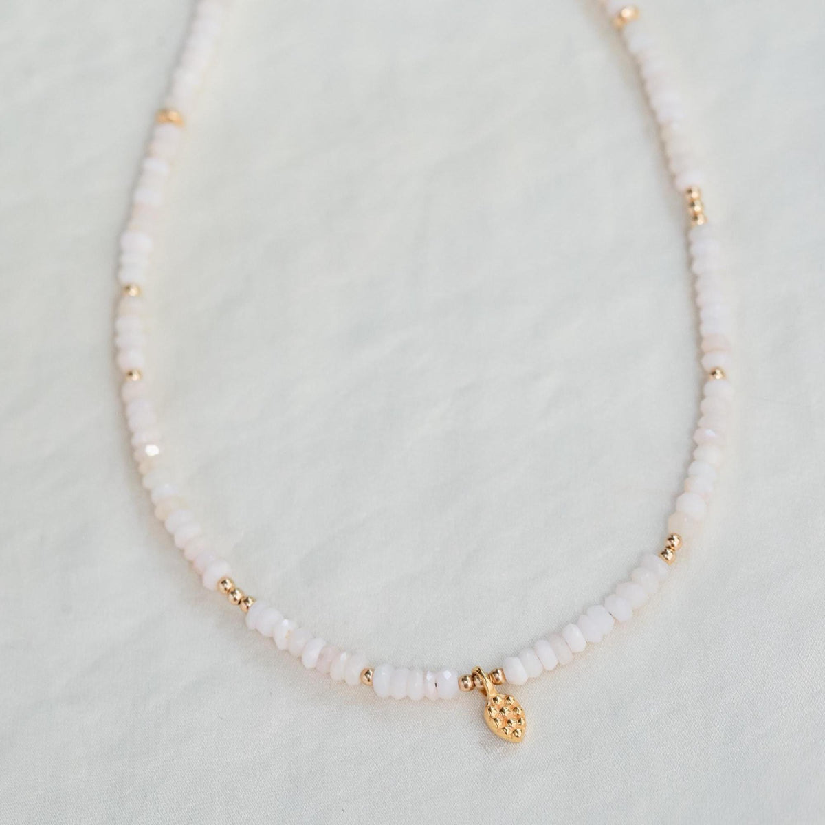 Delicate pink opal necklace from Earthly Abundance featuring a smooth pink gemstone pendant on a fine chain.