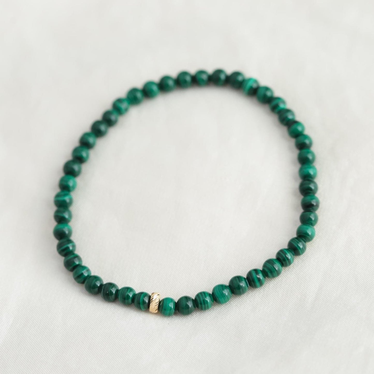 Round 4mm malachite gemstone beads on 14K gold, showcasing vibrant green and natural banding, from Earthly Abundance.