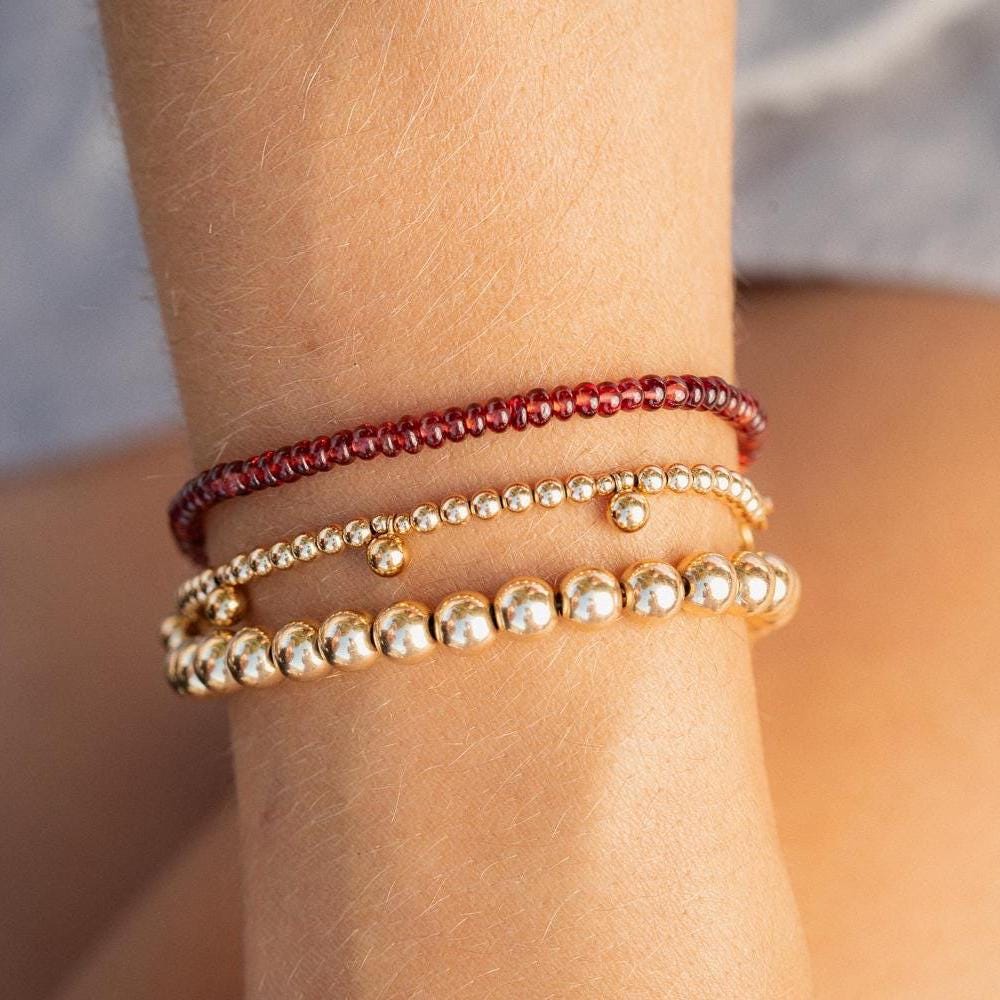 Smooth garnet rondel bracelet by Earthly Abundance featuring polished red gemstone beads on an elastic cord.