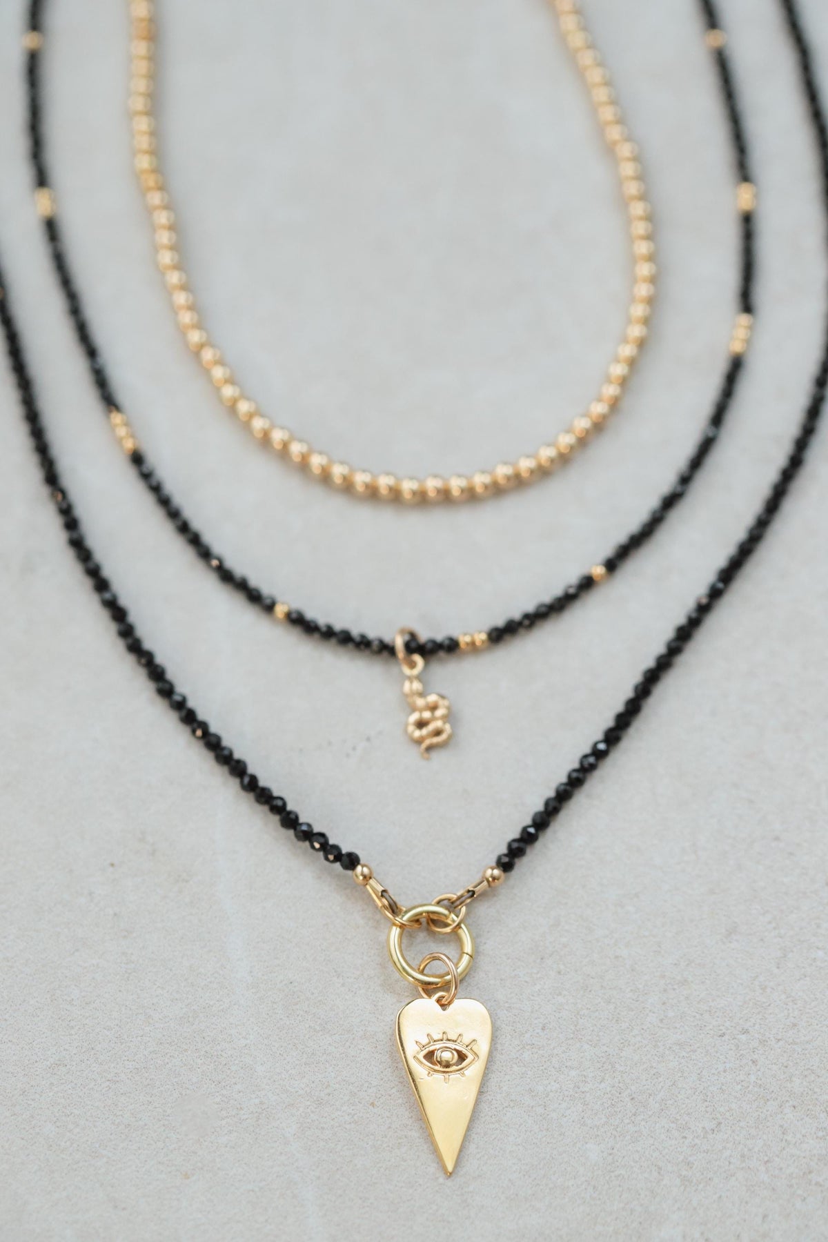 Black Spinel Evil Eye Heart Necklace by Earthly Abundance featuring a pendant with a protective evil eye and heart design.