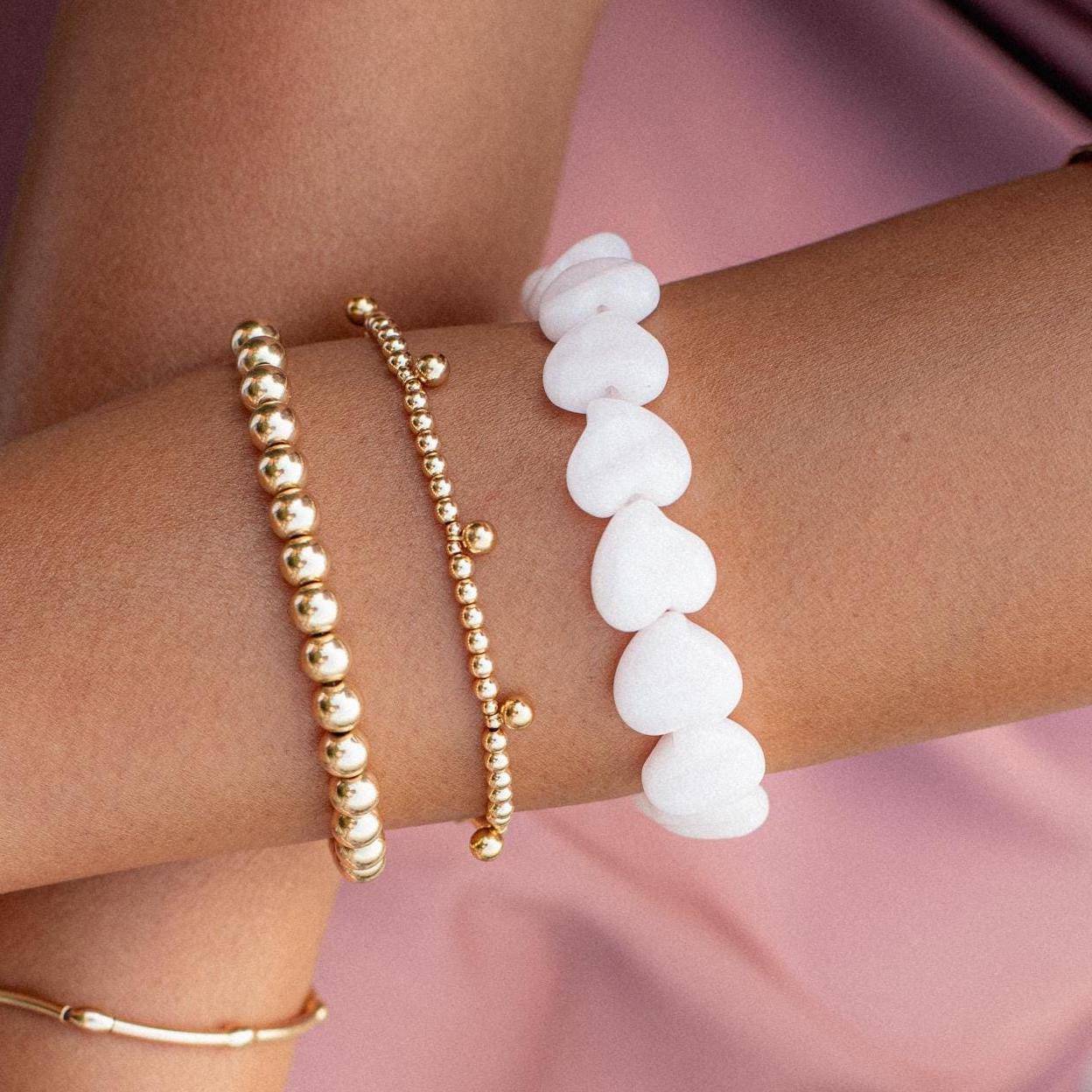 Pink mango calcite heart-shaped bracelet from Earthly Abundance Jewelry featuring pink gemstone beads and a heart charm.