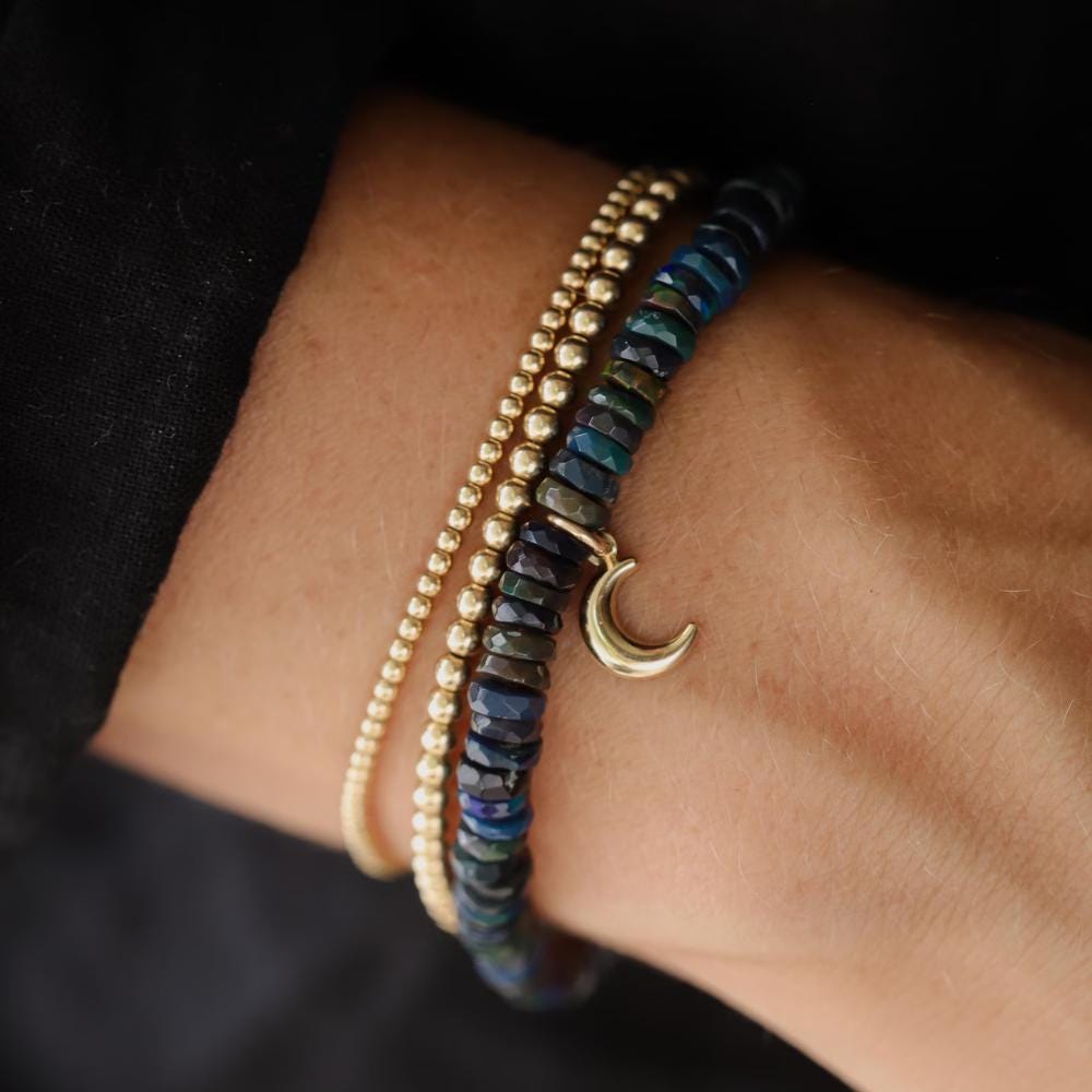 Black Opal Moon Bracelet in 14K gold from Earthly Abundance, featuring a moon-shaped black opal gemstone on a delicate gold chain.