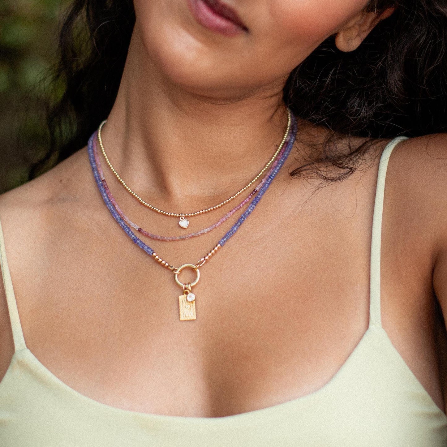 Tanzanite Aura Necklace with a vibrant blue-purple gemstone pendant on a silver chain, crafted by Earthly Abundance Jewelry.