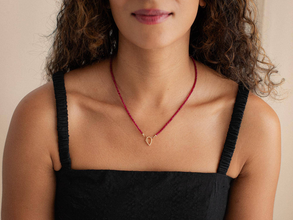 Longido Ruby Carabiner necklace by Earthly Abundance Jewelry featuring a silver chain with a red ruby pendant.