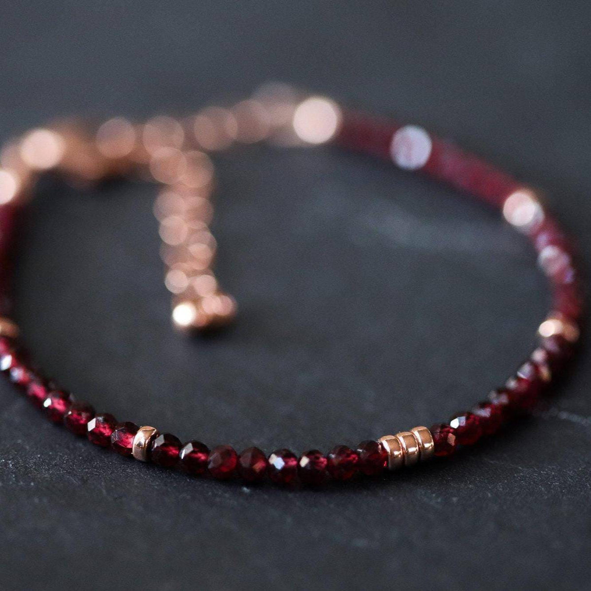 Garnet beaded bracelet from Earthly Abundance Jewelry featuring polished red garnet beads on an elastic cord.