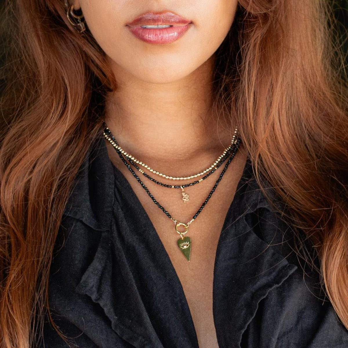 Black Spinel Evil Eye Heart Necklace by Earthly Abundance featuring a black spinel evil eye pendant with a heart-shaped design.