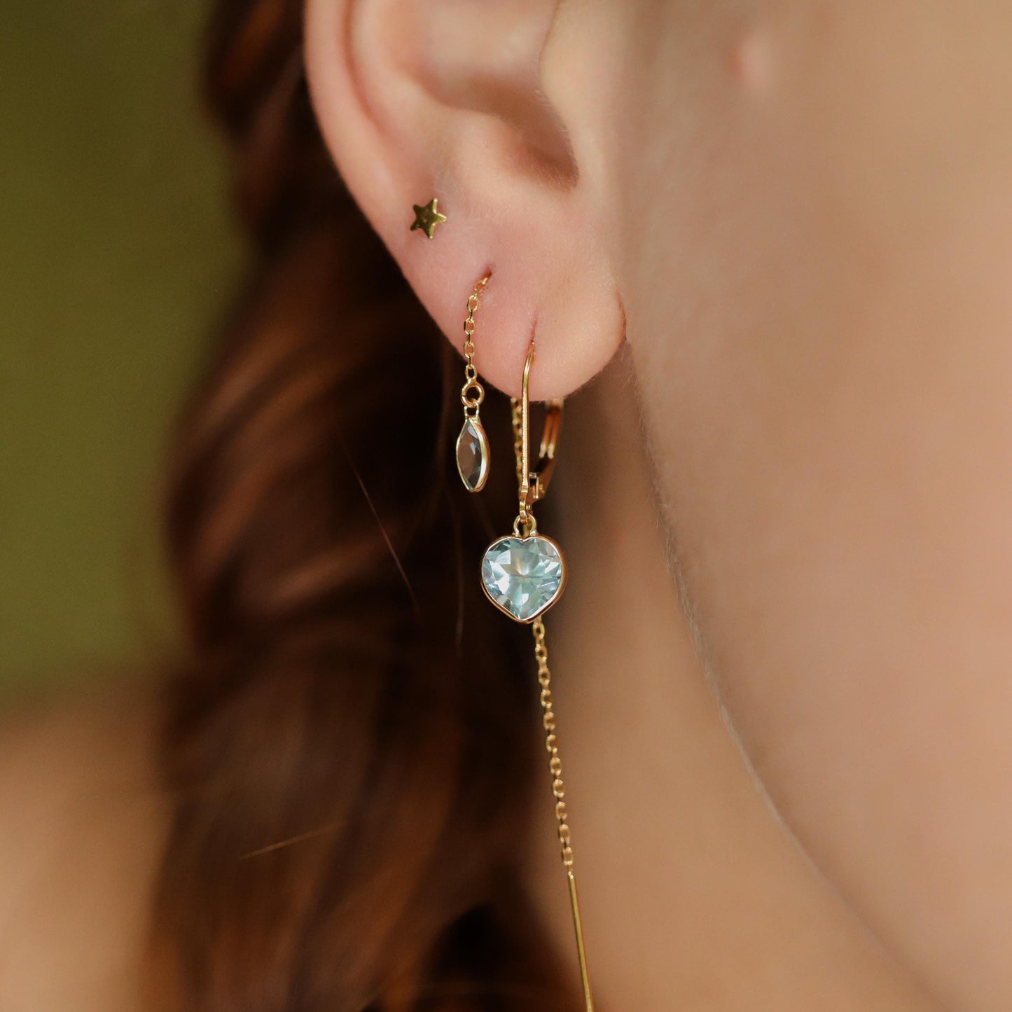 Blue topaz heart earrings crafted in 14K gold from Earthly Abundance featuring sparkling blue topaz stones and elegant heart shapes.