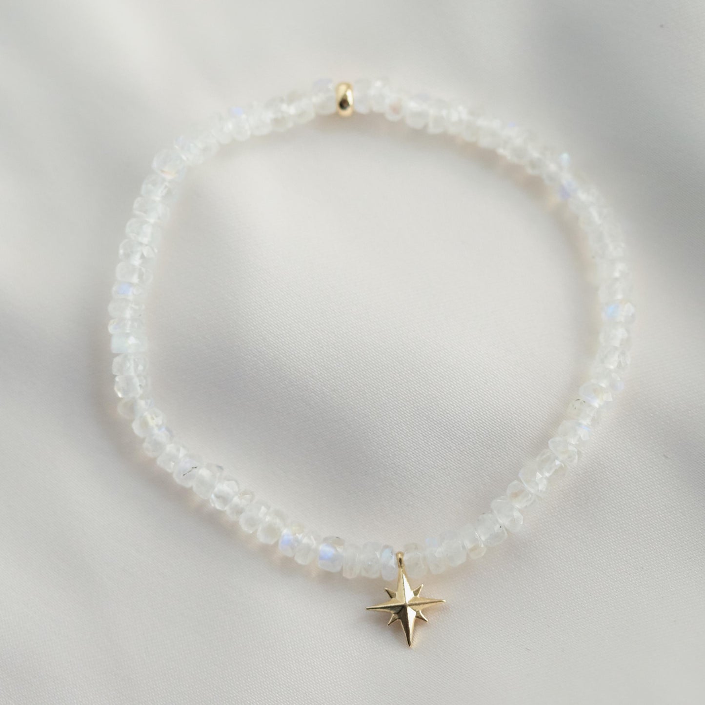 Rainbow moonstone bracelet with 14K gold accents from Earthly Abundance, featuring smooth, polished stones on a delicate gold chain.