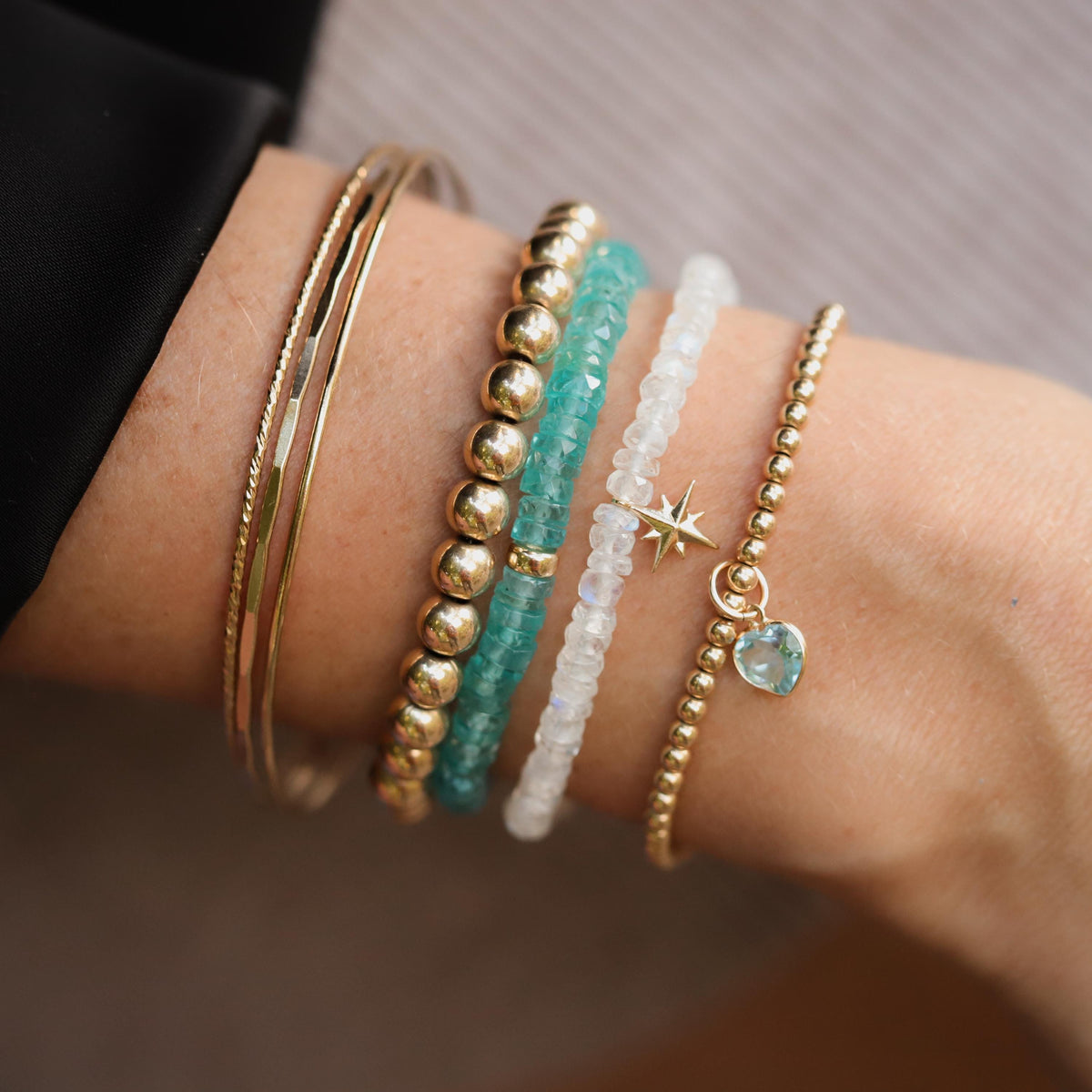 Rainbow moonstone bracelet with 14K gold accents, featuring shimmering, iridescent stones on a delicate jewelry chain.