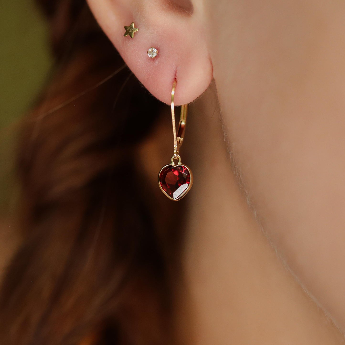 Garnet heart earrings in 14K gold from Earthly Abundance featuring red gemstone hearts with gold hooks.