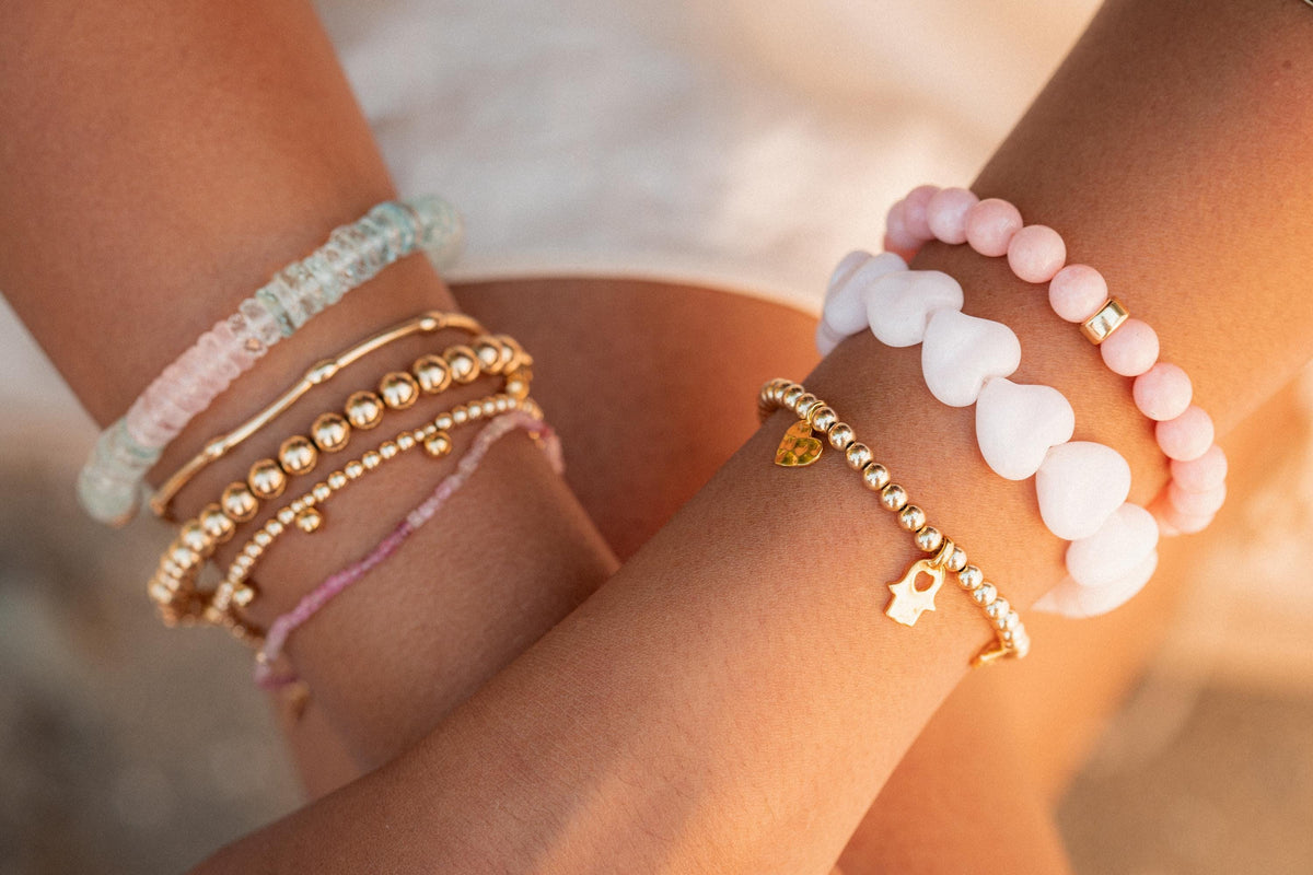 Gold beaded charm bracelet with 4mm beads from Earthly Abundance, featuring a delicate charm and adjustable clasp.