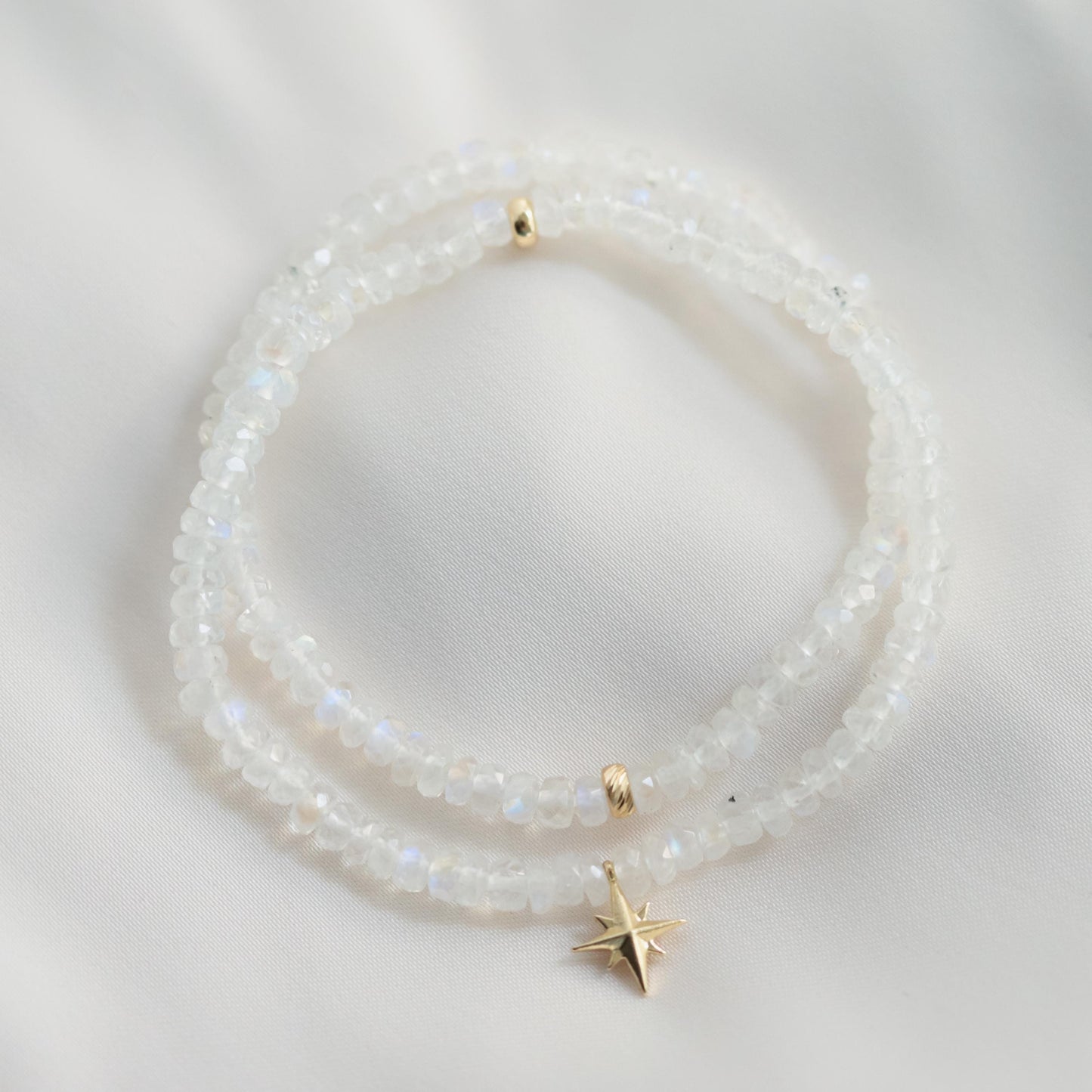 Rainbow moonstone bracelet featuring 14K gold accents, showcasing iridescent moonstone beads on a delicate jewelry design.