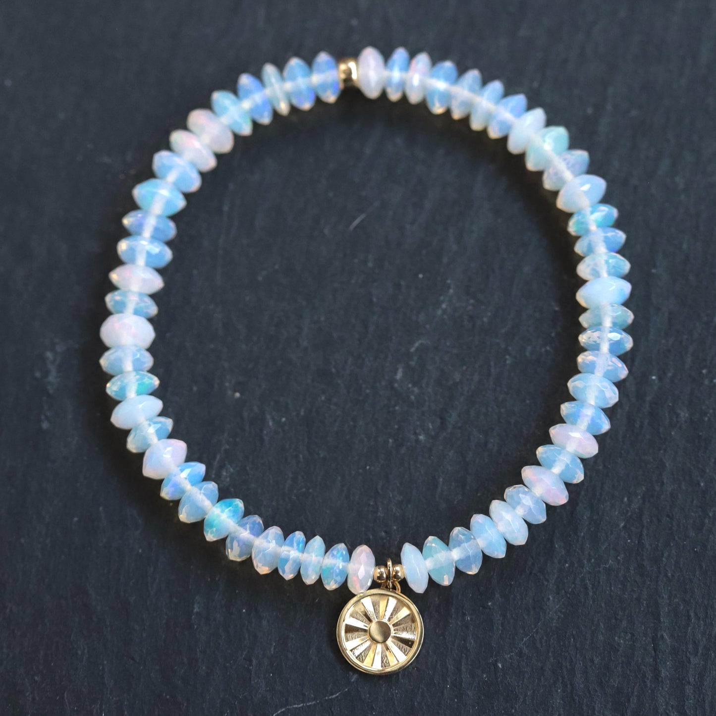 Ethiopian Welo Opal sun bracelet with 14K gold setting, featuring vibrant opal stones and sun-shaped design from Earthly Abundance.