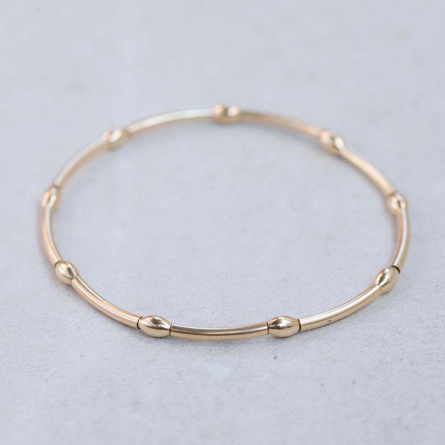14K gold filled curve bracelet by Earthly Abundance featuring a sleek, curved design and a polished finish.