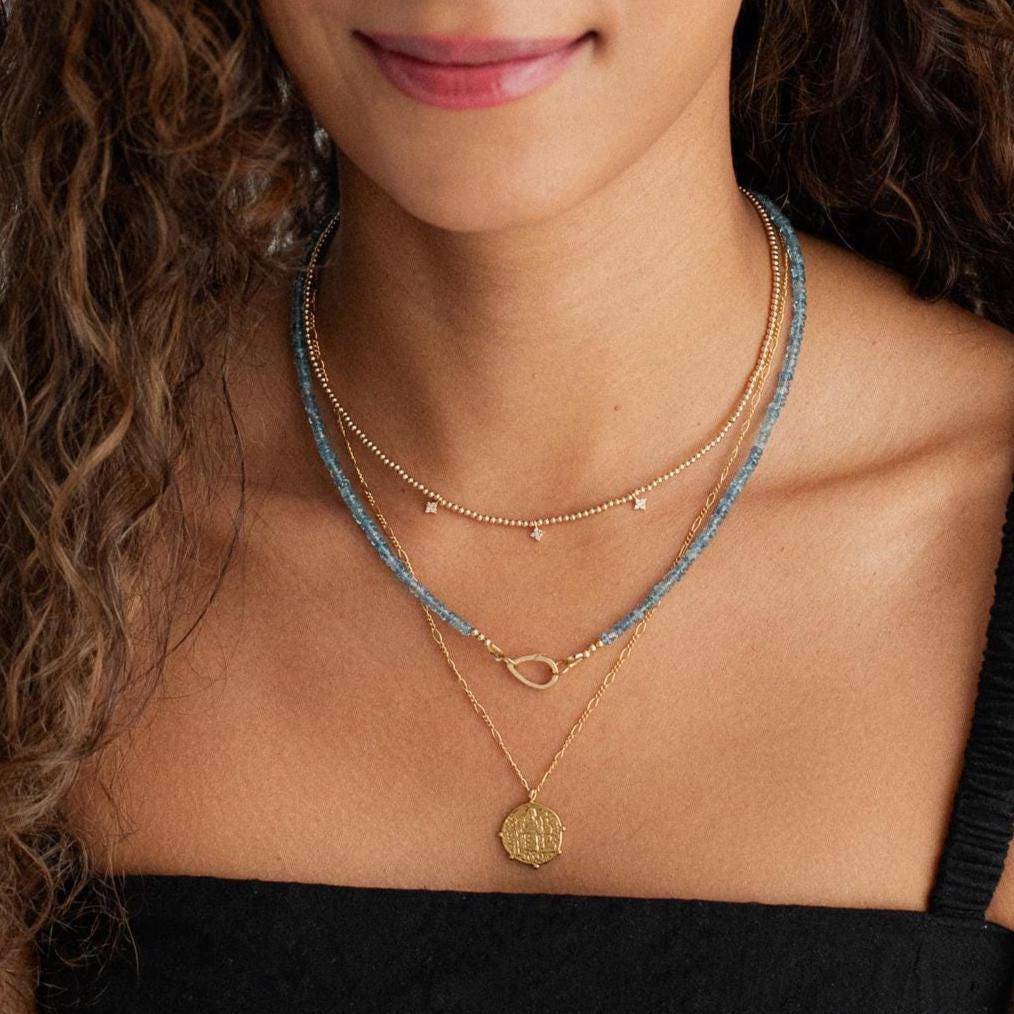 Santa Maria Aquamarine Drop Carabiner by Earthly Abundance featuring a vibrant aquamarine gemstone and a sturdy metal carabiner clip.