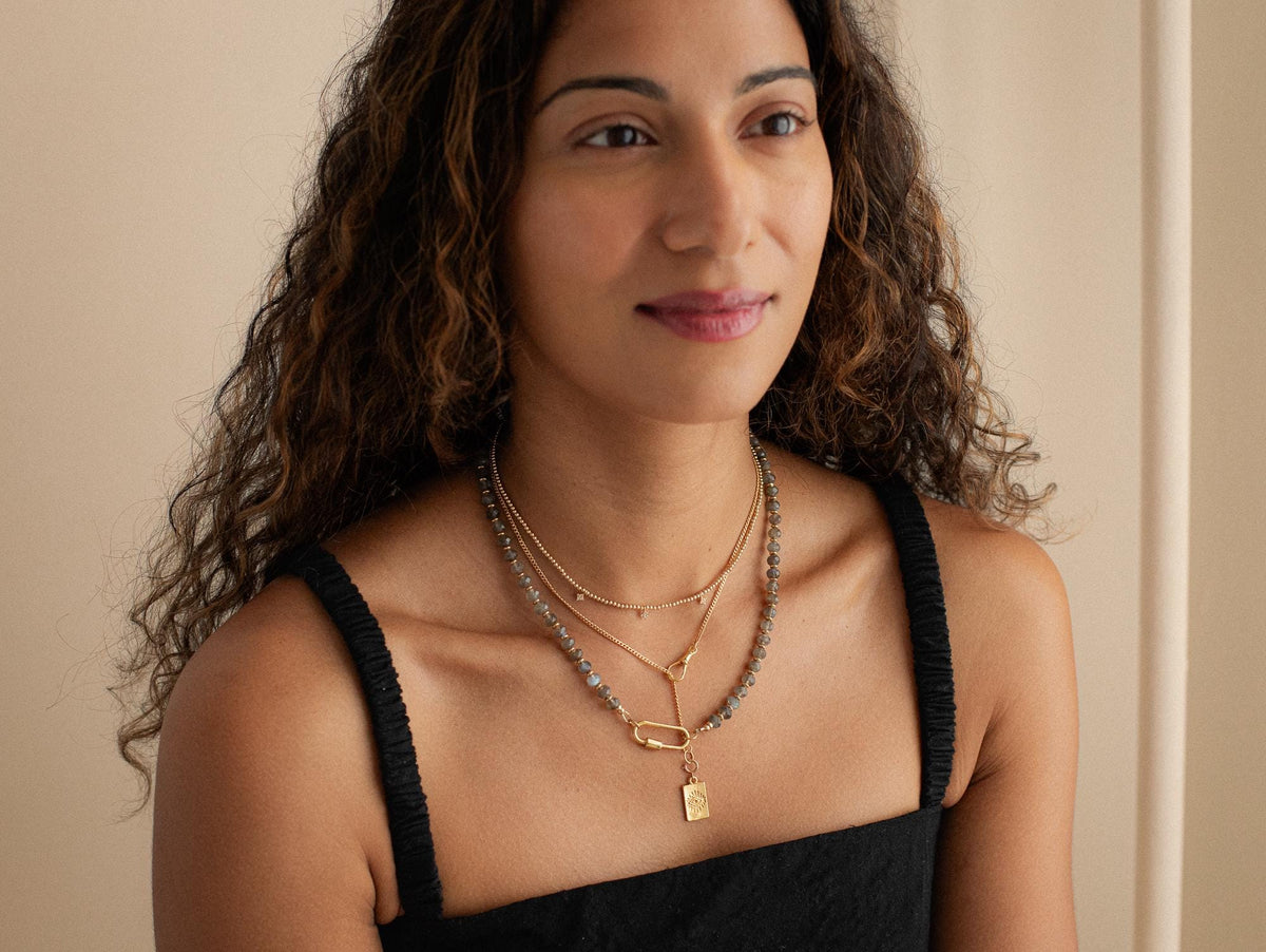 Labradorite carabiner necklace with a polished, iridescent gemstone pendant on a metal chain, designed by Earthly Abundance.