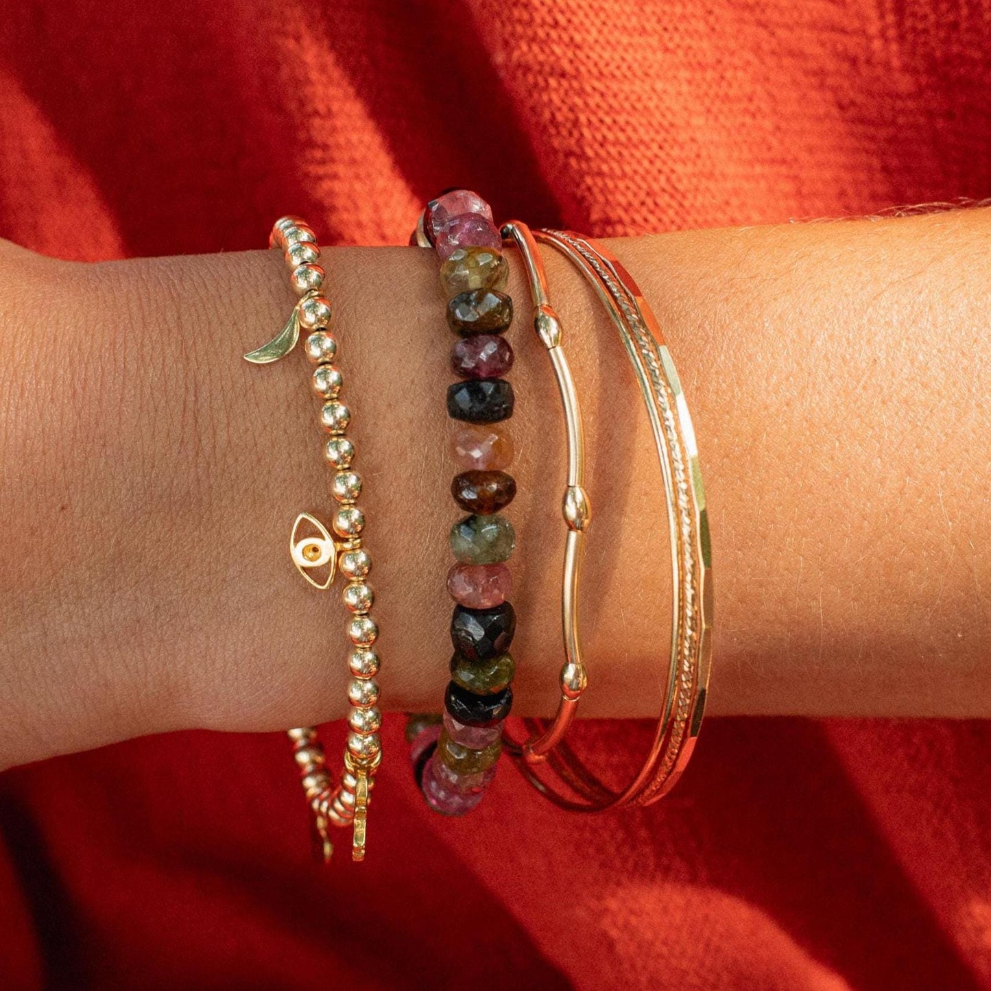 Earthly Abundance tourmaline energy bracelet featuring polished black and green stones on an elastic band.