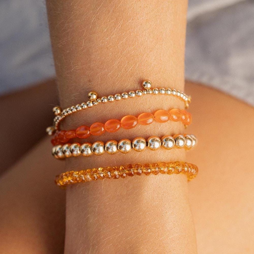 Spessartite Garnet bracelet with vibrant orange stones from Earthly Abundance, showcasing a sleek, elegant jewelry design.