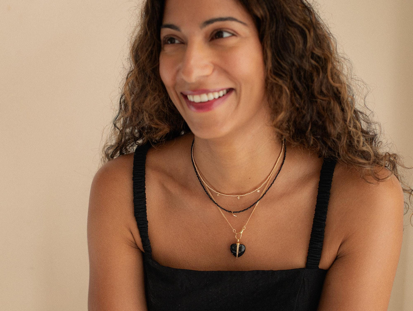 Black spinel moon necklace with 14K gold chain from Earthly Abundance, featuring a moon-shaped pendant with black gemstone details.