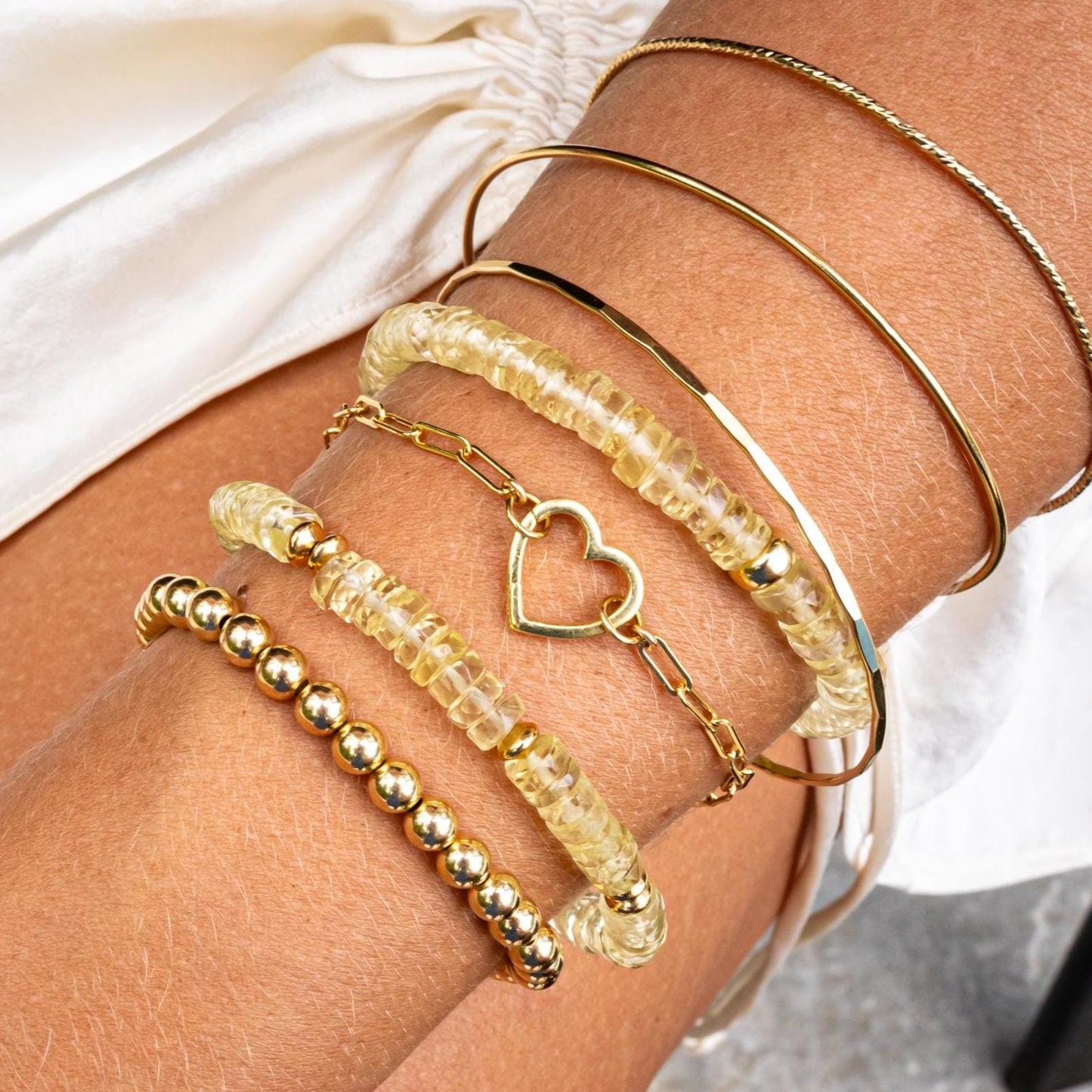 Natural Lemon Quartz bracelet featuring polished yellow quartz beads, strung on elastic cord, with a focus on bright, vibrant gemstone.