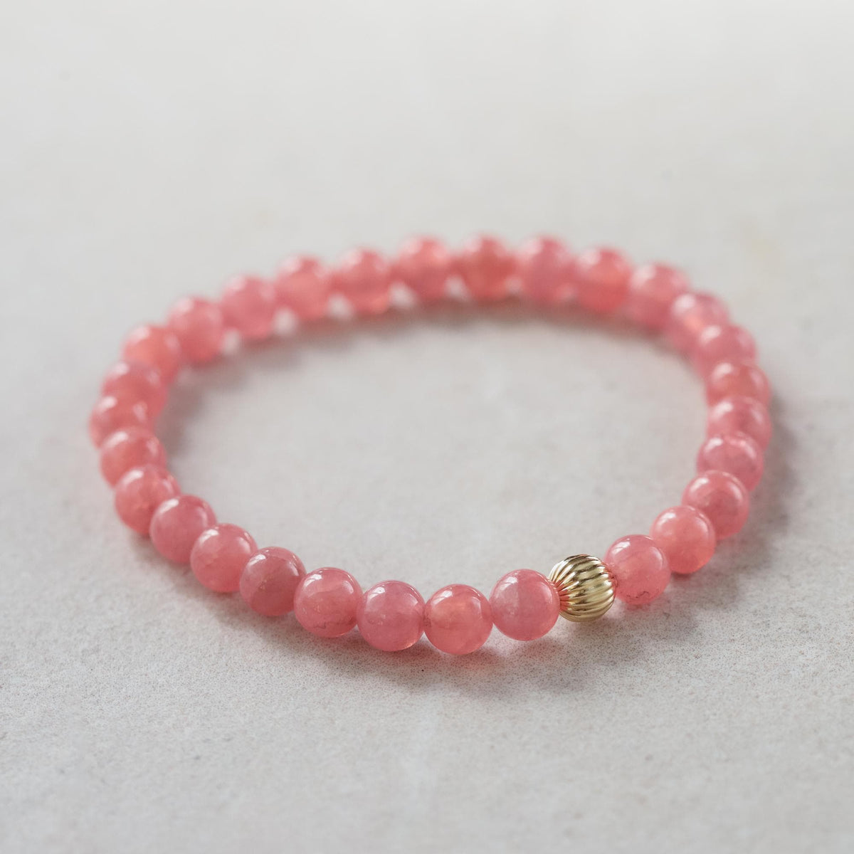 Rhodochrosite pendant in 14K gold from Earthly Abundance Jewelry, showcasing a vibrant pink gemstone with gold setting.