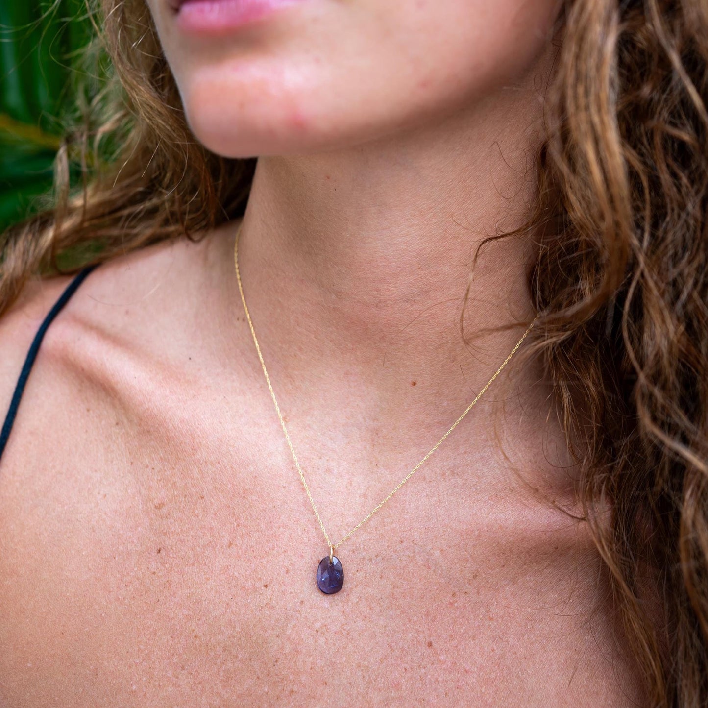 Amethyst pendant in 14K gold from Earthly Abundance, featuring a polished purple gemstone on a delicate chain.