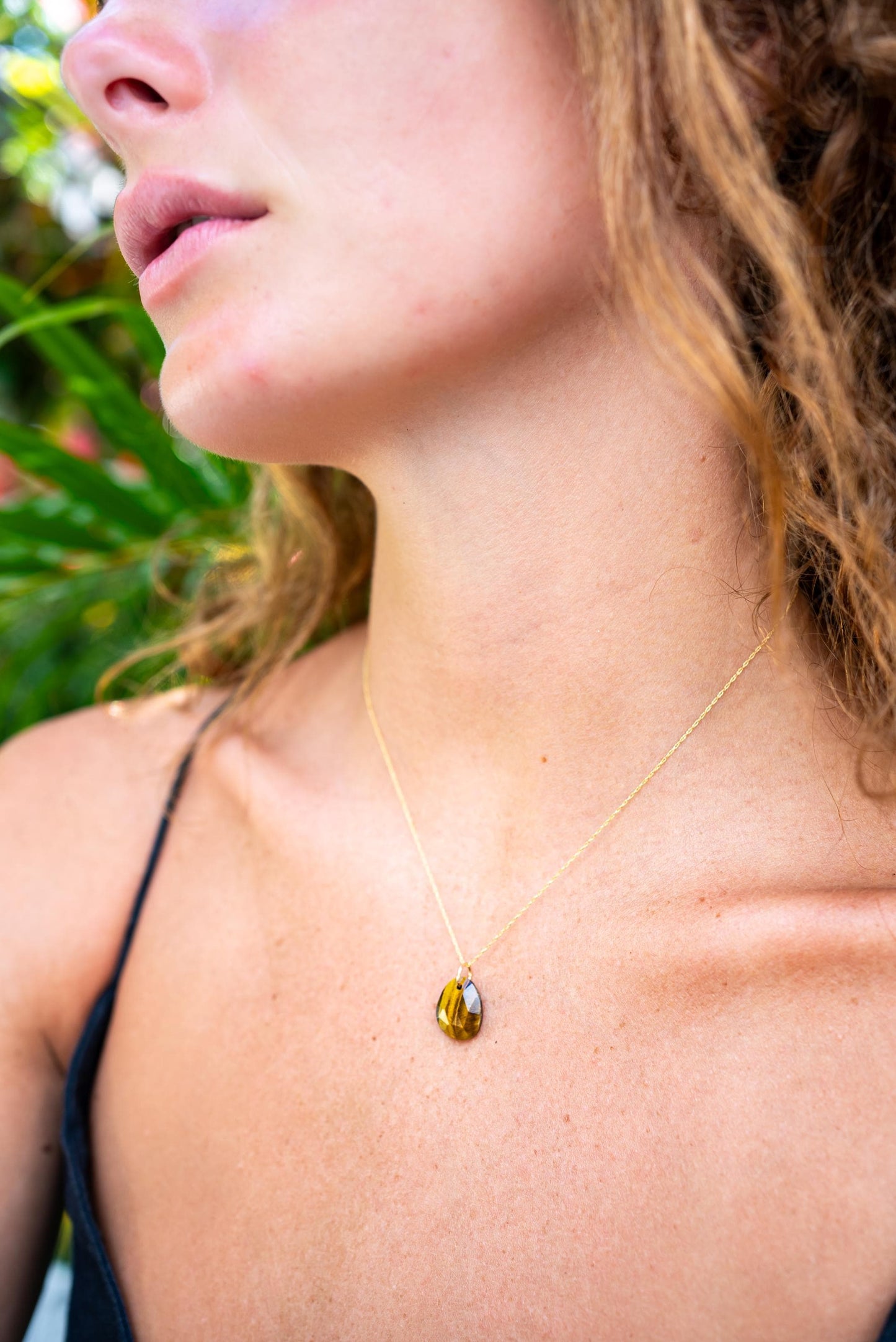 Tiger's eye pendant from Earthly Abundance featuring a polished, golden-brown gemstone on a silver chain.