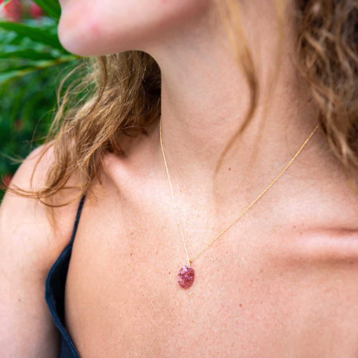 Strawberry Quartz pendant necklace by Earthly Abundance featuring a polished pink gemstone on a silver chain.