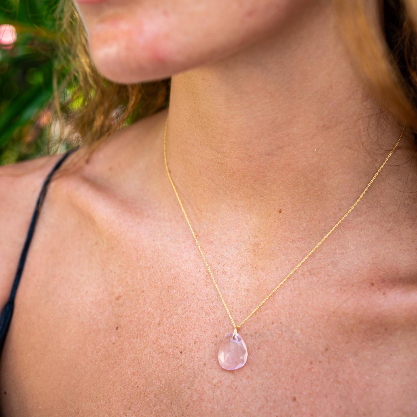 Rose quartz pendant necklace with 14K gold setting, featuring a polished pink gemstone on a delicate chain.