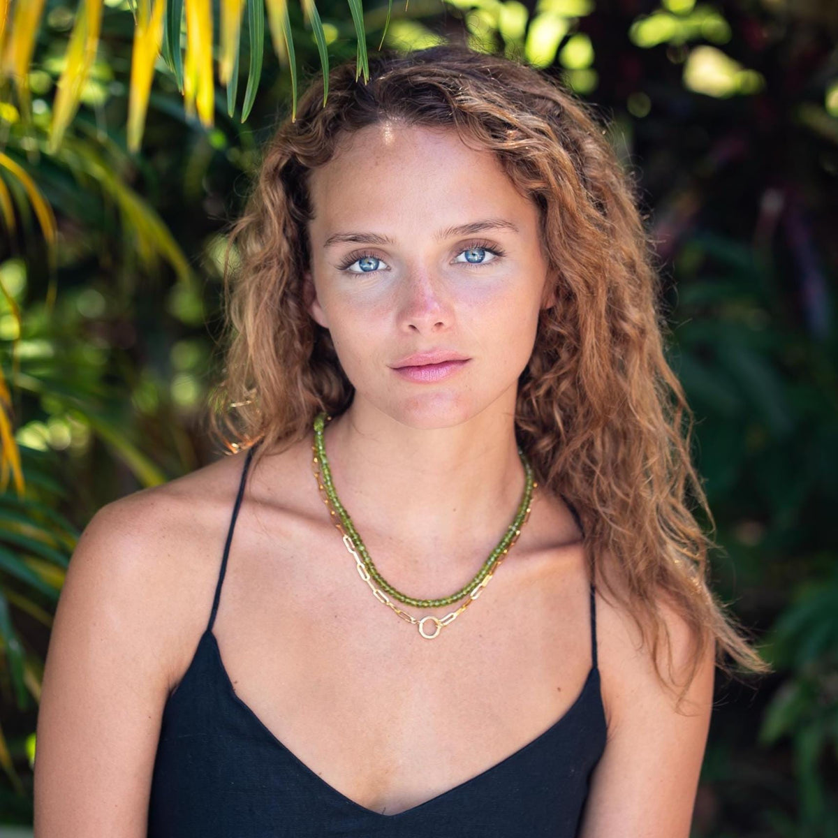 Peridot gemstone necklace in 14K gold from Earthly Abundance, featuring a vibrant green peridot pendant on a delicate chain.