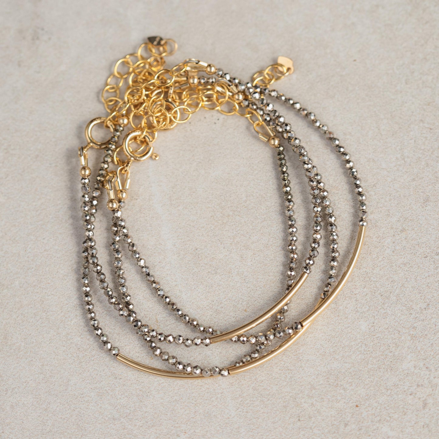 Earthly Abundance pyrite bracelet featuring polished gold-toned pyrite stones on an elastic band, close-up view of the jewelry.