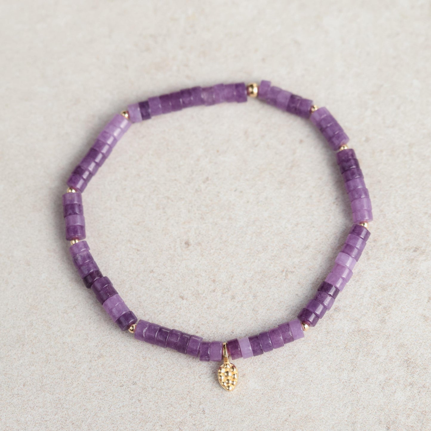Lepidolite Heishi bracelet featuring small purple and gray gemstone beads from Earthly Abundance, worn on a person's wrist.
