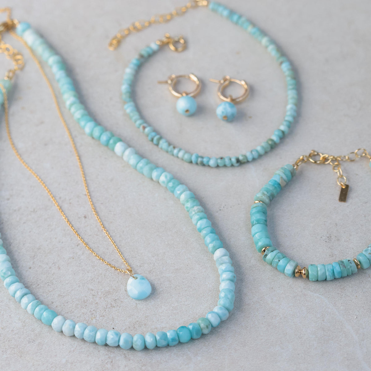 Larimar pendant necklace by Earthly Abundance featuring a smooth, blue gemstone pendant hanging from a silver chain.