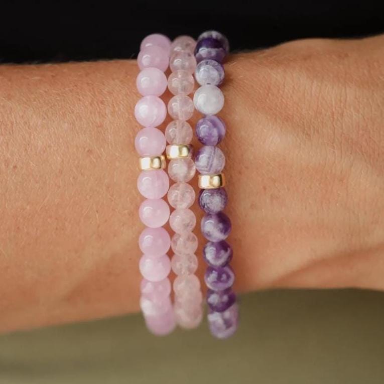 Chevron Amethyst bracelet by Earthly Abundance featuring polished purple and white gemstone beads on an elastic cord.