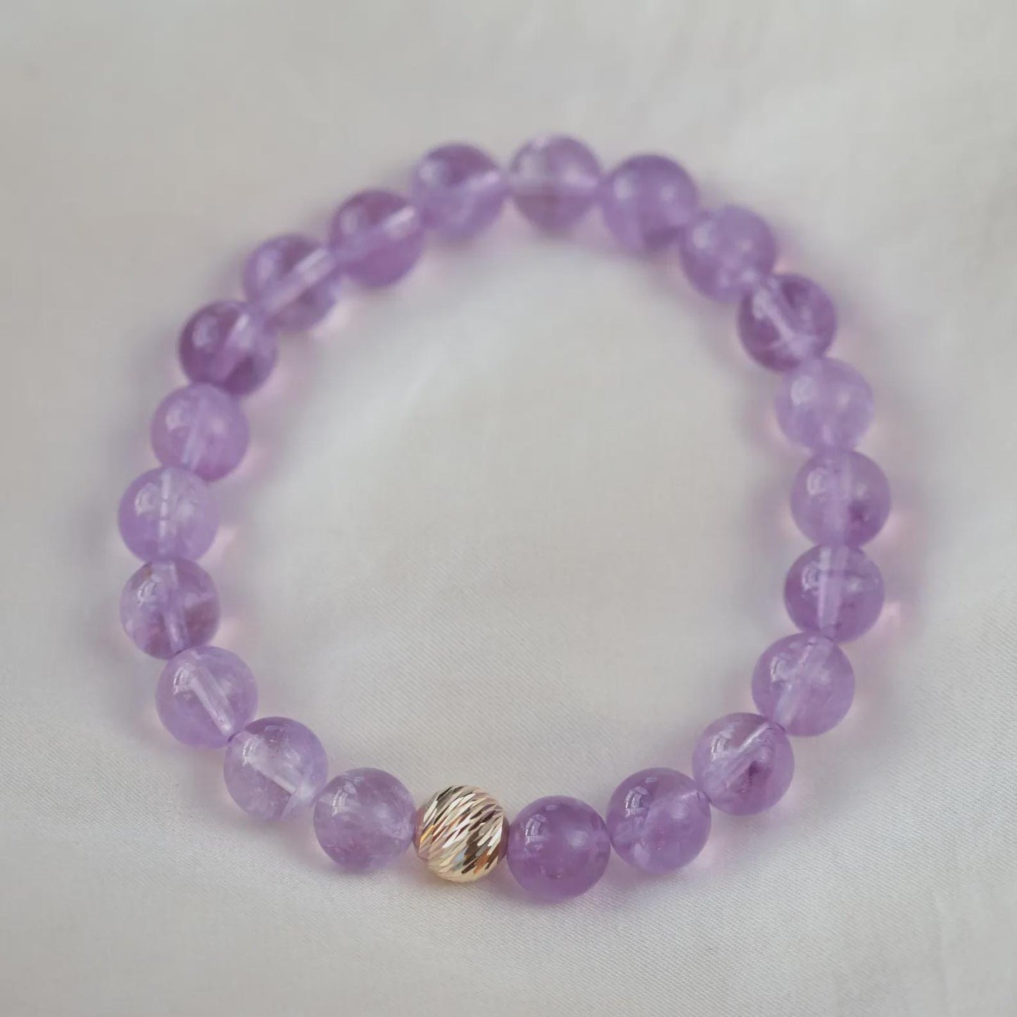 Lavender Amethyst bracelet with 14K gold accents from Earthly Abundance, featuring polished amethyst beads and elegant design.