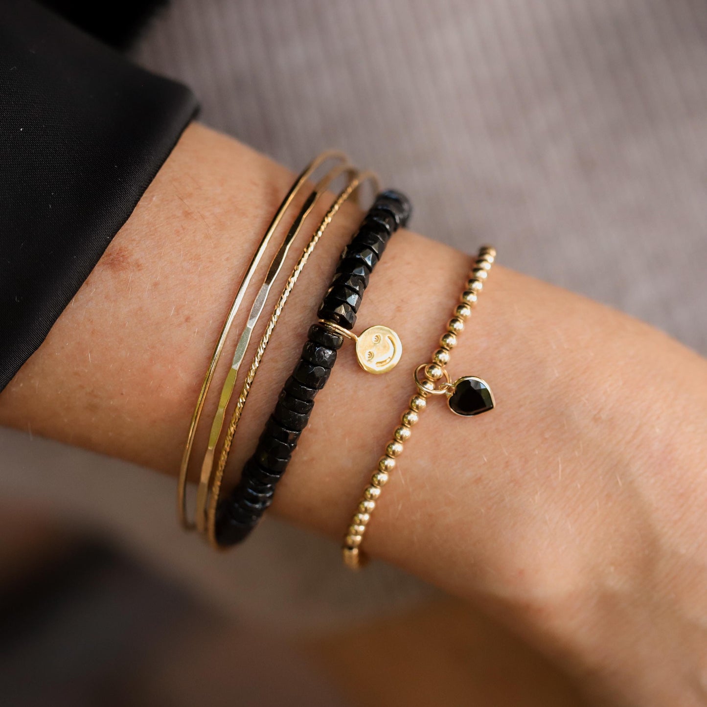 Gold filled black spinel heart bracelet with 14K gold charm by Earthly Abundance, featuring black spinel beads and a delicate heart pendant.