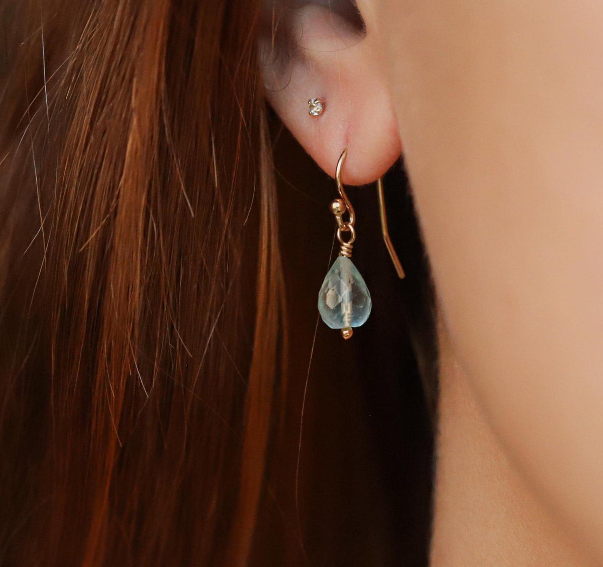 Faceted aquamarine drop earrings by Earthly Abundance featuring shimmering blue gemstones hanging from silver hooks.