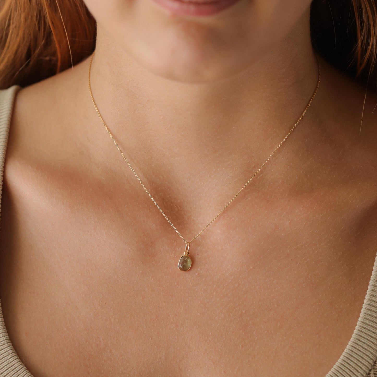 Green tourmaline necklace with 14K gold chain from Earthly Abundance, featuring a vibrant green gemstone pendant.