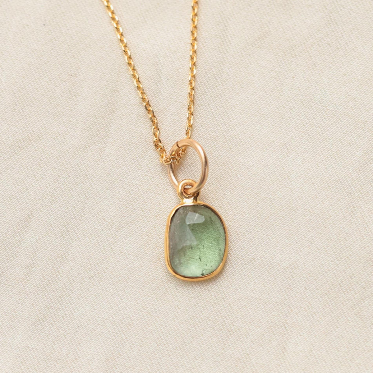 Green tourmaline necklace with 14K gold chain from Earthly Abundance, showcasing a vibrant green gemstone pendant.