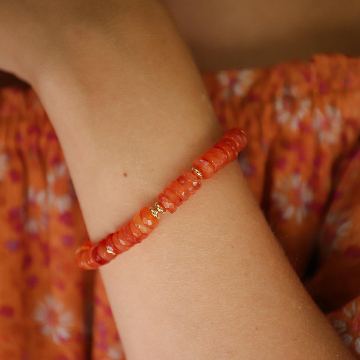 Carnelian beaded bracelet by Earthly Abundance featuring vibrant orange-red polished beads on an elastic band.