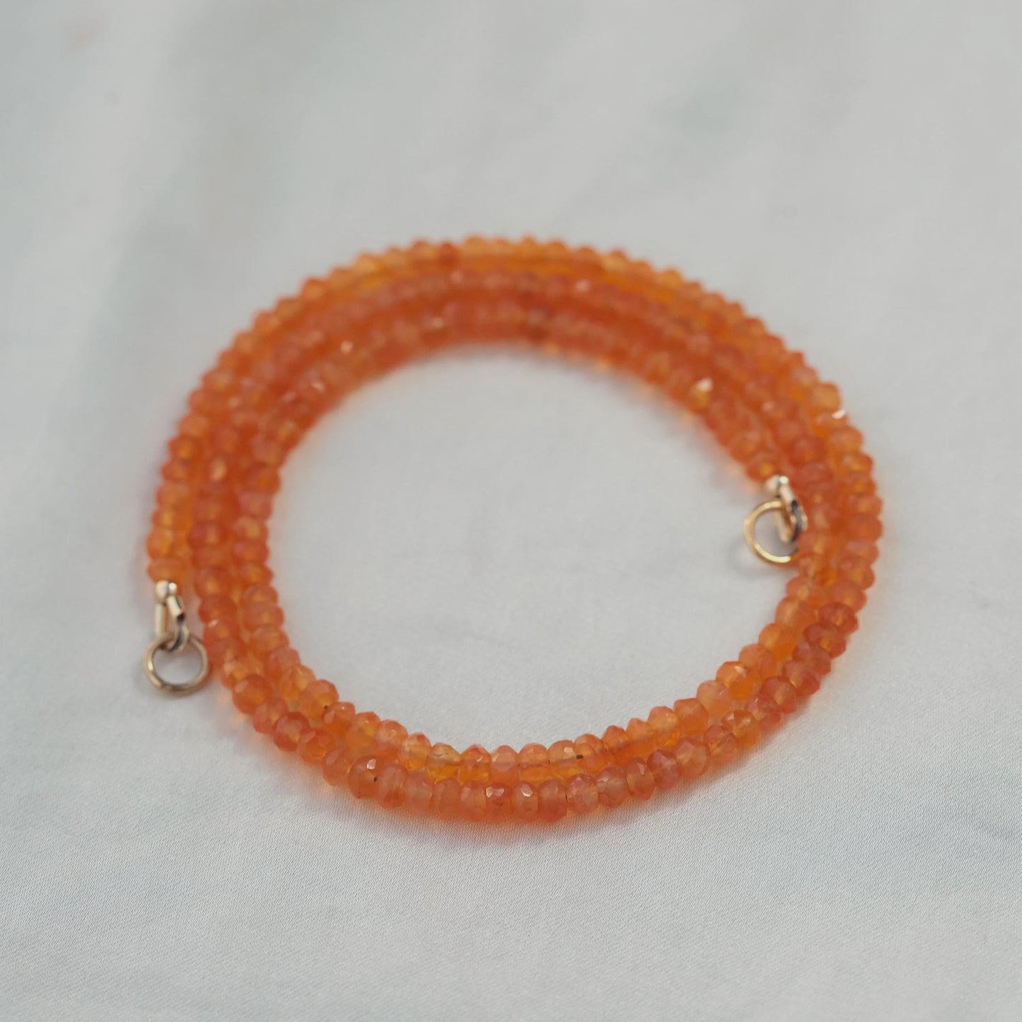 Carnelian carabiner necklace with silver accents from Earthly Abundance, featuring a vibrant orange stone and sturdy metal clasp.