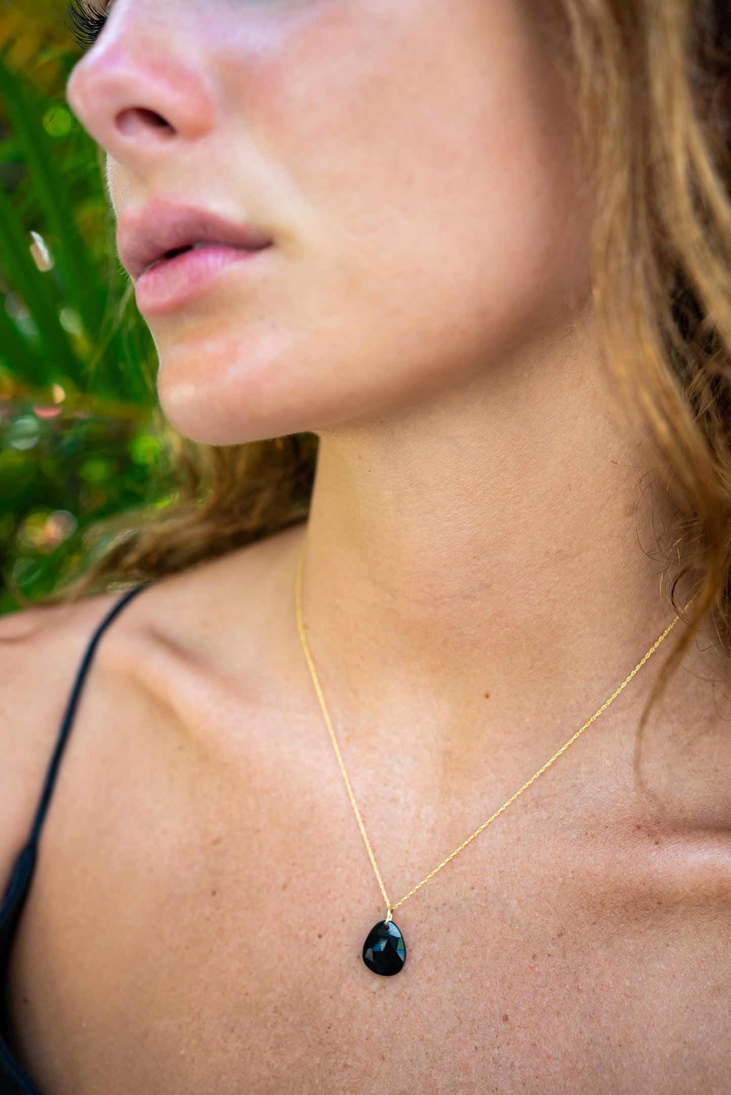 Black Onyx pendant necklace in 14K gold setting, featuring a polished black gemstone on a delicate chain.